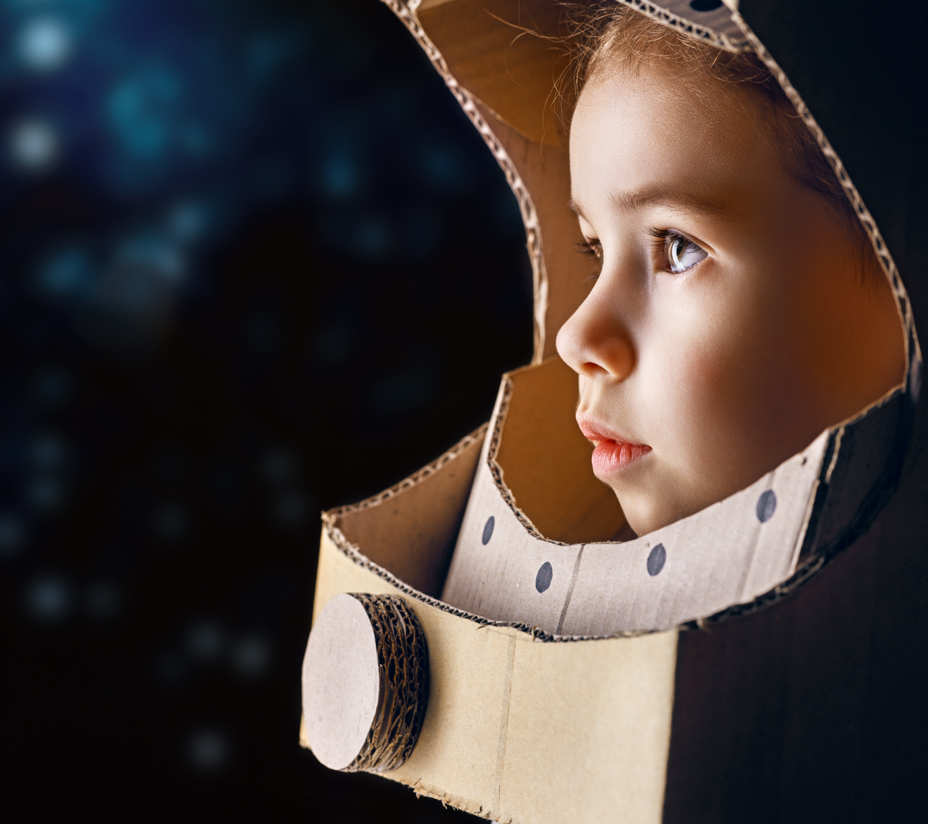 A child in a homemade space helmet looks off into the distance